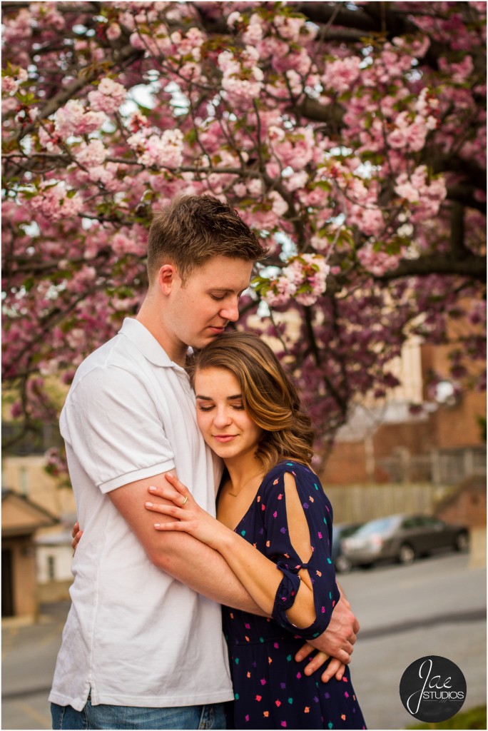 Hannah & Nick-28, Lynchburg Couple Session, Cherry Blossoms, Hugging, Brunette, White Shirt, Blue Patterned Dress