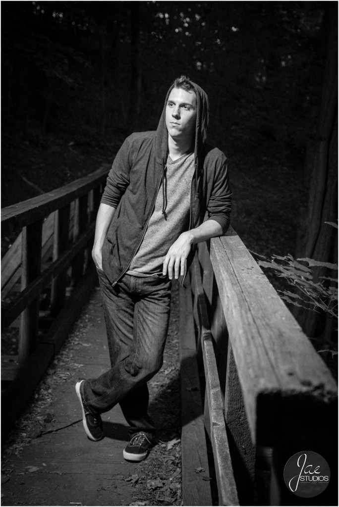 Andrew. Liberty University, Class of 2015, senior pictures, Lynchburg, Virginia, Jae Studios, black jacket, gray shirt, jeans, hoodie, wooden fence, leaning, black and white