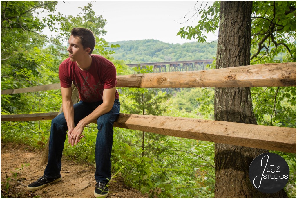 Andrew. Liberty University, Class of 2015, senior pictures, Lynchburg, Virginia, Jae Studios, wooden fence, sitting, red shirt, jeans, green