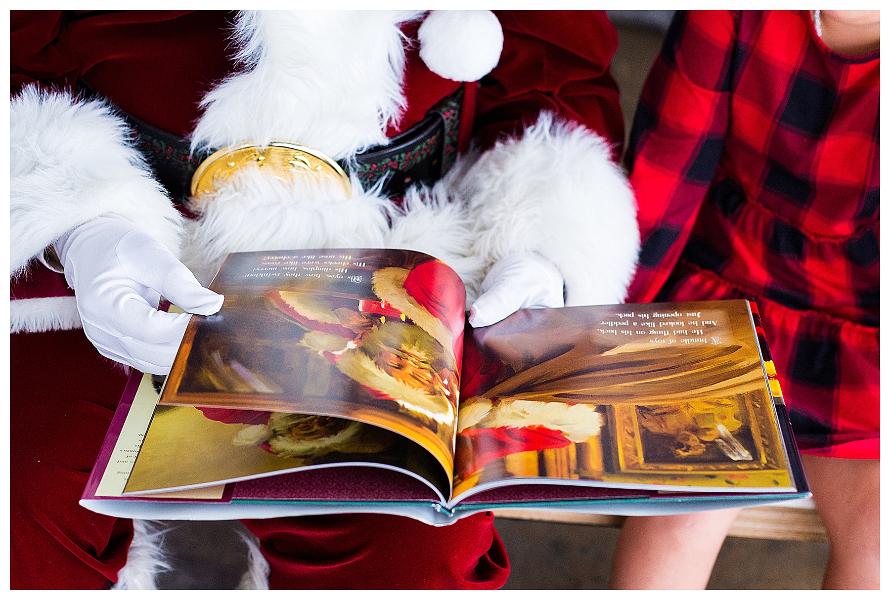Santa's hand holding a story book implying the reading for the story book to a young girl.